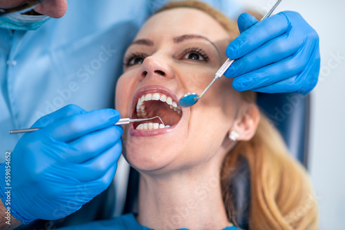 Male dentist checking patient teeth