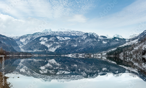 Cloudy winter Alpine lake Grundlsee panorama (Austria) with fantastic pattern-reflection on the water surface.