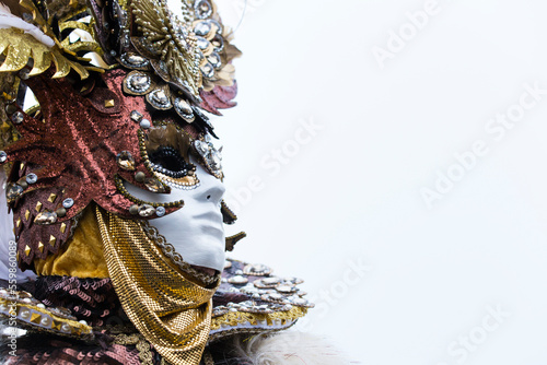 Ritratto orizzontale di maschera al carnevale di venezia, decentrata sulla sinistra con spazio grigio uniforme a destra photo