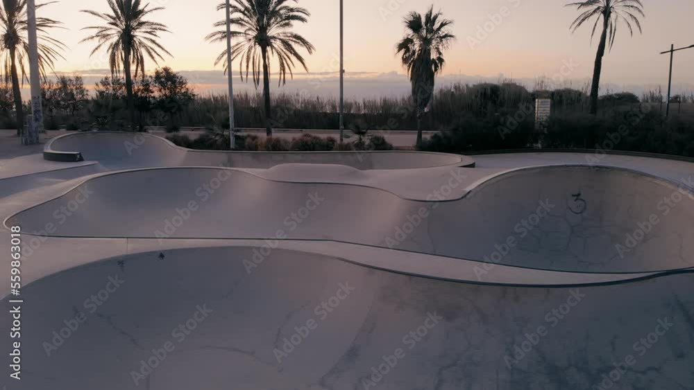 Aerial drone reveal of empty skateboard pool in sunrise or sunset in summer. Millennial modern sport activity. Cinematic California lifestyle view. Aerial drone reveal of empty skateboard pool in sunrise or sunset in summer. Millennial modern sport activity. Cinematic California lifestyle view.