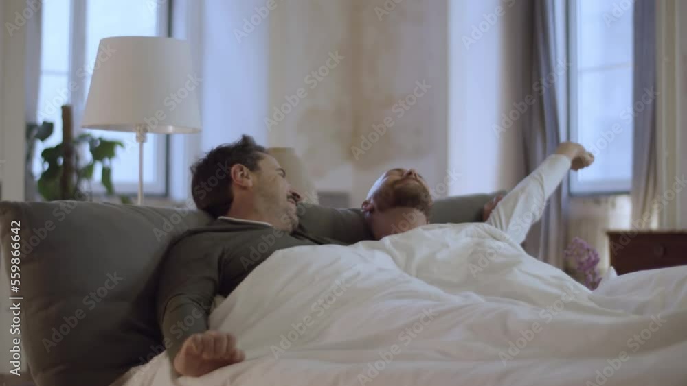 Handsome Caucasian men lying in bed in morning and kissing. Medium shot of bearded homosexual men waking up, stretching, looking at each other with tenderness. LGBT, love, sleep cycle concept Handsome Caucasian men lying in bed in morning and kissing. Medium shot of bearded homosexual men waking up, stretching, looking at each other with tenderness. LGBT, love, sleep cycle concept
