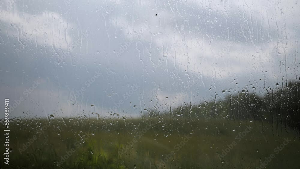 Rain window closeup cinematic water field country outside storm Rain window closeup cinematic water field country outside storm