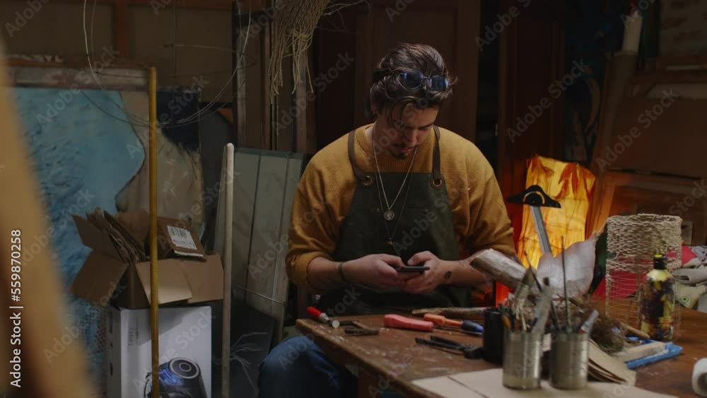 craftman using mobile phone in his workshop craftman using mobile phone in his workshop