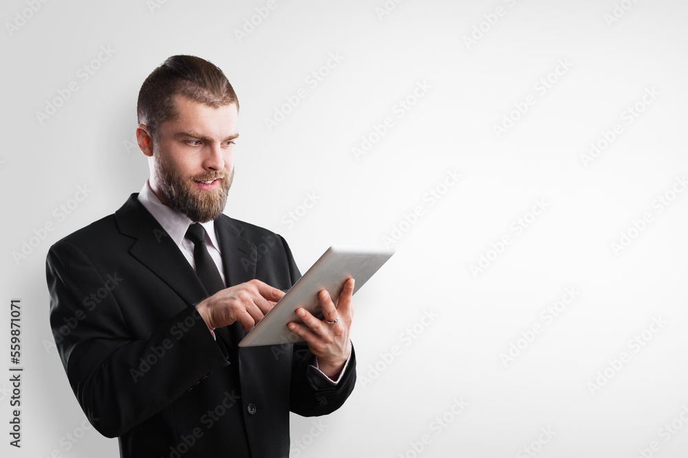 Cheerful young business man works on digital tablet Cheerful young business man works on digital tablet