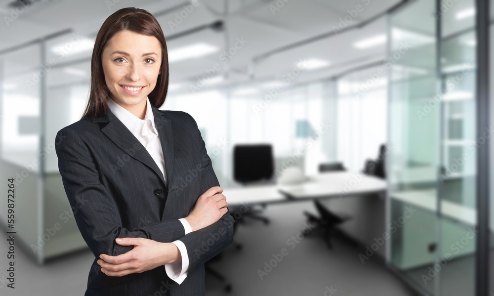 Powerful toung business woman standing in office Powerful toung business woman standing in office