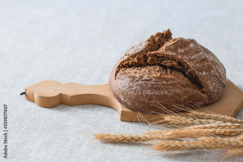 Fresh delicious bread close-up. Freshly baked sourdough bread with a golden crust on a wooden board. The context of a bakery with delicious bread. Confectionery products. Fresh delicious bread close-up. Freshly baked sourdough bread with a golden crust on a wooden board. The context of a bakery with delicious bread. Confectionery products.