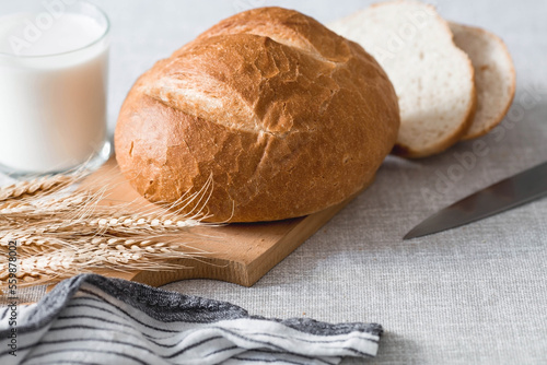 Fresh delicious bread close-up. Freshly baked sourdough bread with a golden crust on a wooden board. The context of a bakery with delicious bread. Confectionery products.