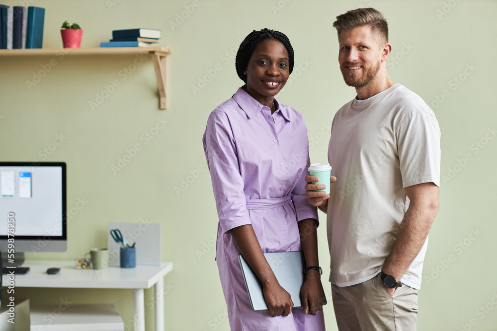 Minimal waist up portrait of two young business people, man and woman looking at camera against pastel green wall, copy space Minimal waist up portrait of two young business people, man and woman looking at camera against pastel green wall, copy space