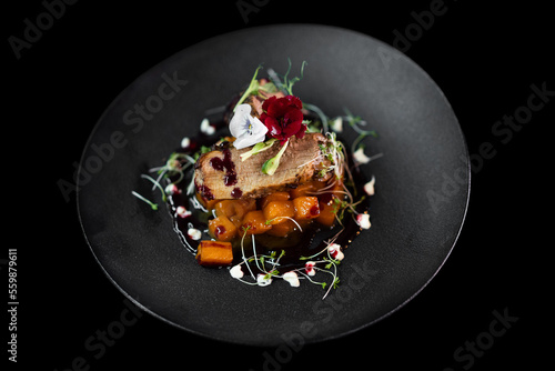 close up of an exquisite serving of a special dish from the chef on a black plate