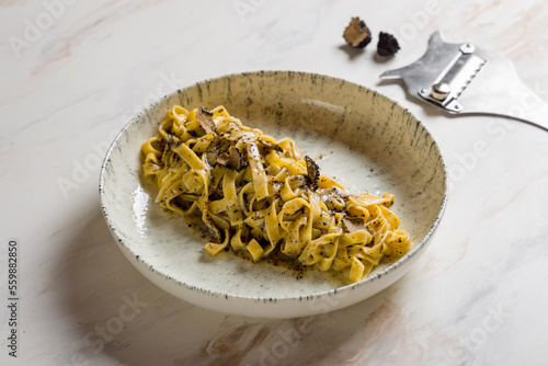 tagliatelli pasta with black truffle on marble table photo