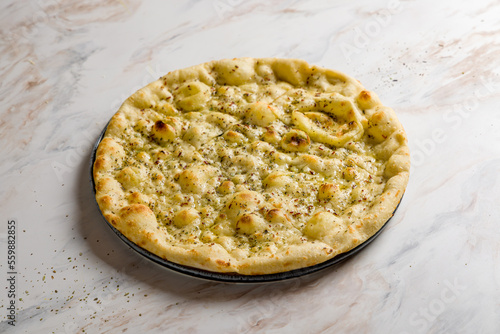 focaccia with oregano and olive oil on white marble table photo