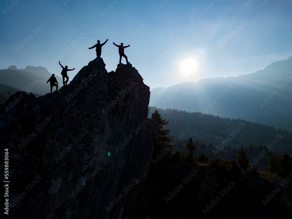 successful climbers on the jagged cliff at the top of the mountains