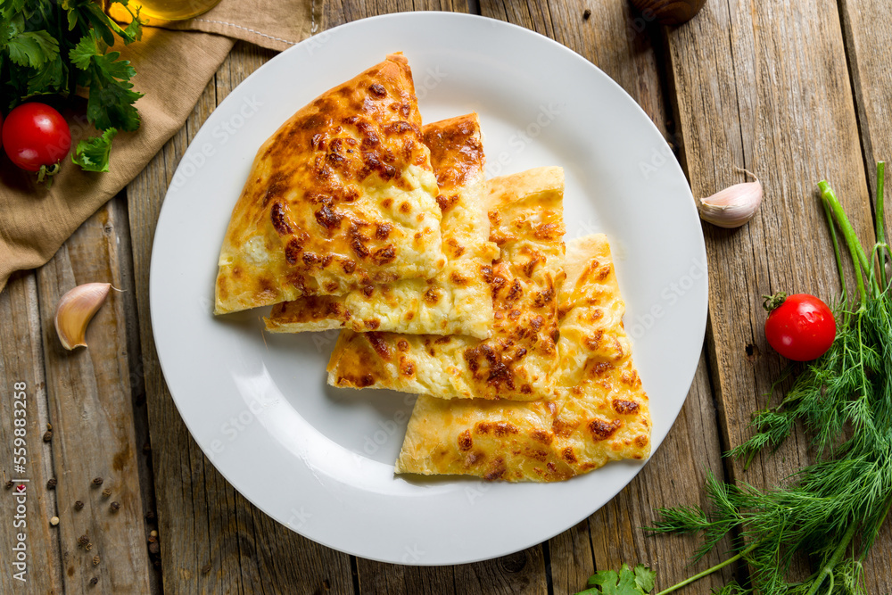 khachapuri with cheese, megrelian khachapuri, georgian cuisine on wooden table top view khachapuri with cheese, megrelian khachapuri, georgian cuisine on wooden table top view