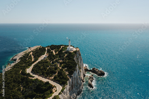 View on seascape and lighthouse with turquoise clear waters and trees in Greece