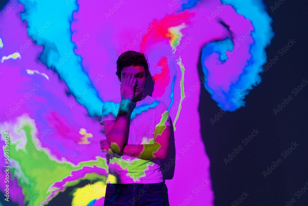 Talented Innovative boy with an interactive virtual video installation. New art form, generative graphics. Silhouette of young man draws digital art in augmented virtual reality