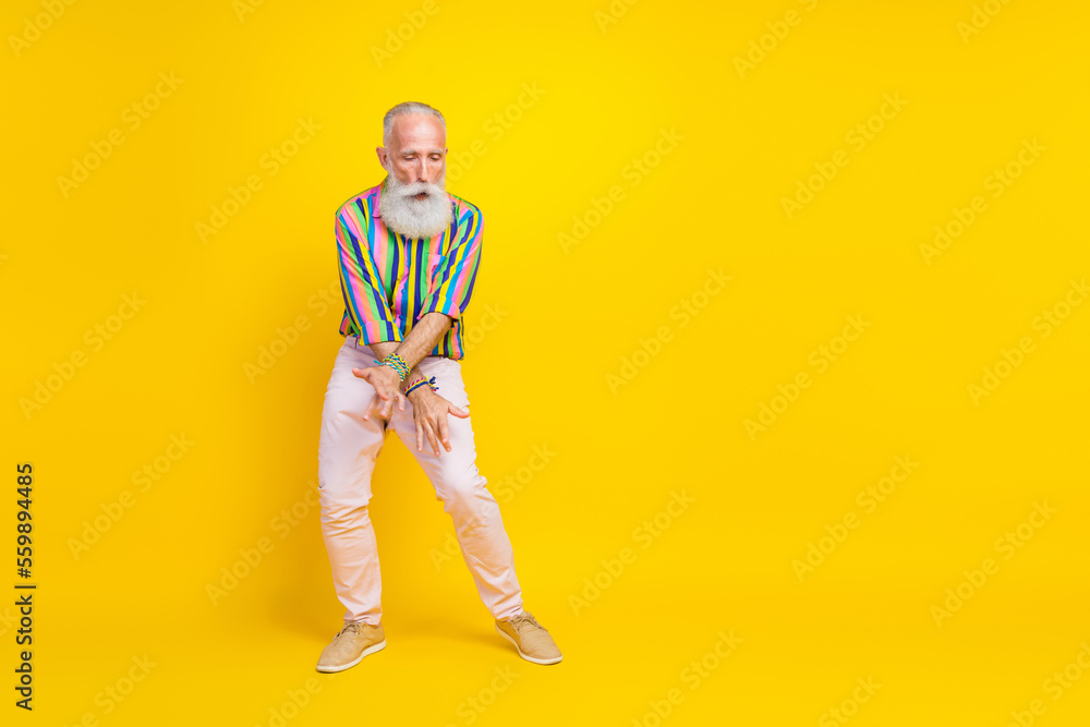 Full length photo of excited cheerful man wear colorful shirt having fun empty space isolated yellow color background