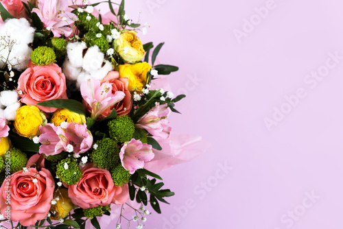 Bouquet of pink, yellow roses and purple flowers alstroemeria on a purple background. Birthday greeting card, Valentine's Day, Mother's Day