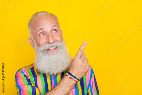 Fototapeta Photo of dreamy positive man wear colorful shirt looking showing finger empty sp