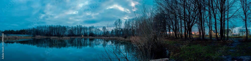Panoramic photo during steel hour on an almost windless evening with a smooth lake. Panoramic photo during steel hour on an almost windless evening with a smooth lake.