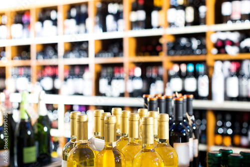 Closeup view on wine supermarket shelves with wide assortment of wine bottles