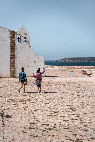turistas paseando tomando selfie en el cabo de san vicente portugal. photo