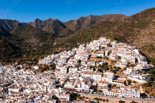 Drone view of the small town with white houses and surrounding countryside, Ojen, Spain in the summer