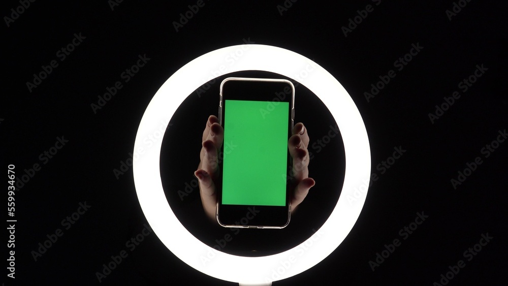 female hands show the phone close-up on a black background. green screen mockup for insert ads female hands show the phone close-up on a black background. green screen mockup for insert ads