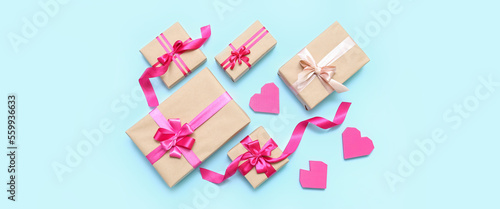 Composition with beautiful gift boxes and hearts on light blue background. Valentine's Day celebration