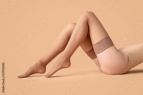 Woman in nude stockings lyi...
