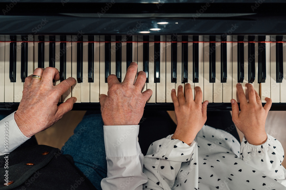 Close-up of senior piano student hands with her granddaughter playing the  piano Stock Photo | Adobe Stock