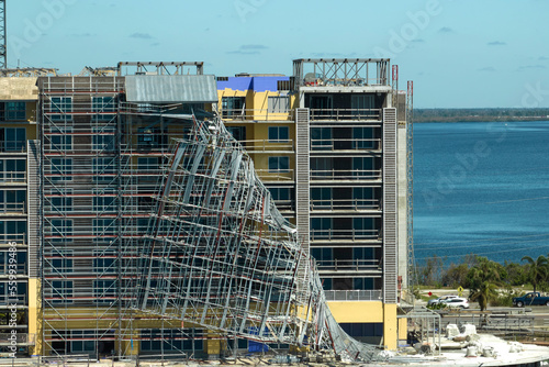 Aerial view of ruined by hurricane Ian construction scaffolding on high apartment building site in Port Charlotte, USA