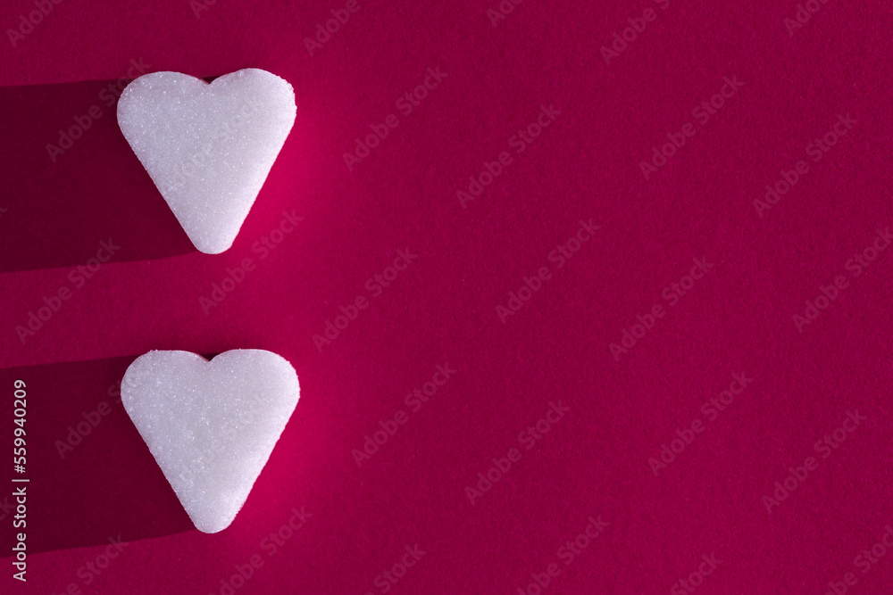 Obraz premium Sugar cube in heart form on a magenta background with deep shadow. Love concept macro