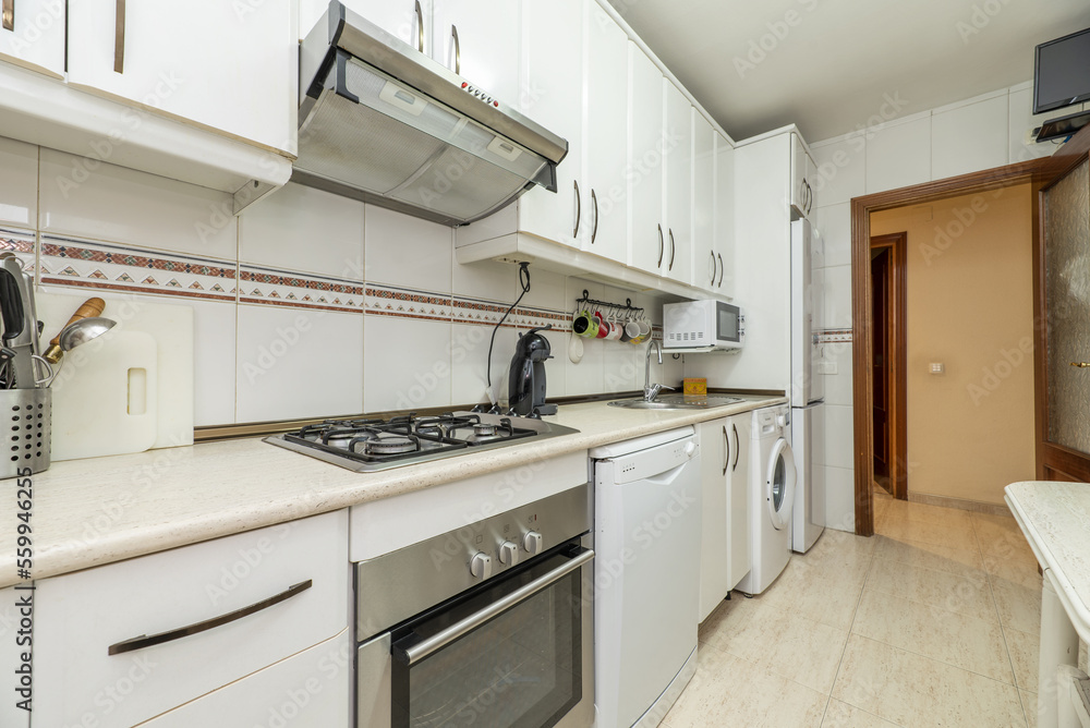Old kitchen with white cabinets and appliances of all kinds and colors, cream countertops and matching tiles Old kitchen with white cabinets and appliances of all kinds and colors, cream countertops and matching tiles