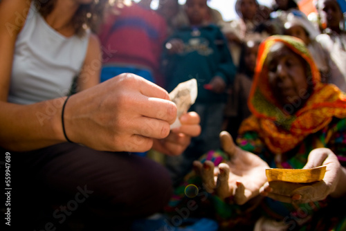 Female exchanging the local currency for some food with older woman. Bright colors and and blurred image of the local children. photo