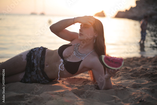 beautiful youg woman witha watermelon in a beach photo