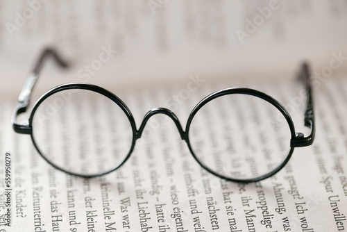 Reading glasses close-up on a book on a light blurred background.Education and schooling concept.Symbol of study  knowledge and reading.