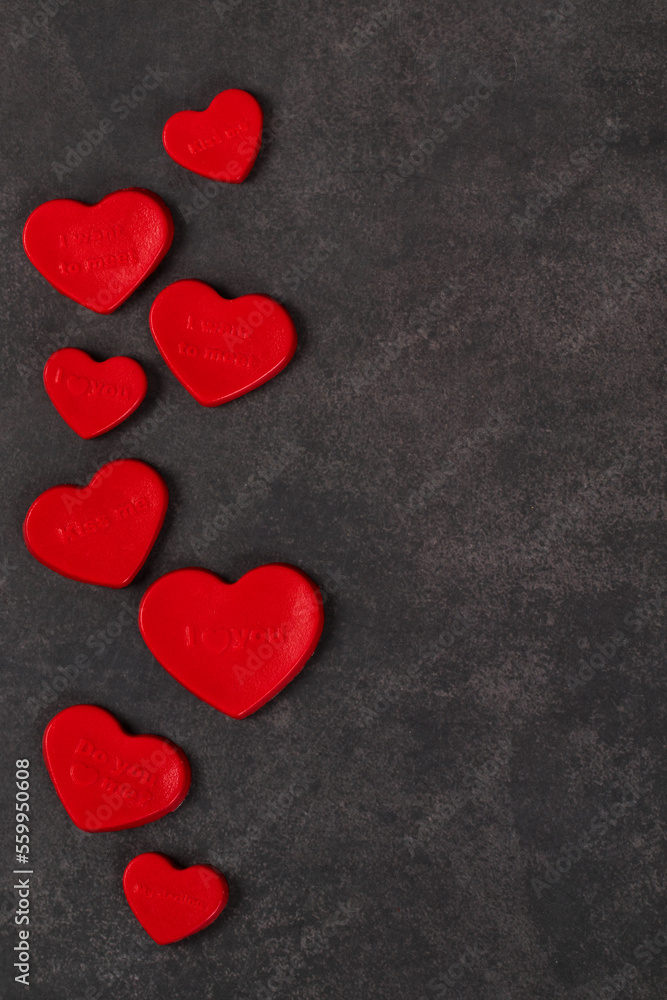 Creamy jelly candy in the shape of a red heart with thematic inscriptions. Valentine's Day. Dark gray background. Copy space Creamy jelly candy in the shape of a red heart with thematic inscriptions. Valentine's Day. Dark gray background. Copy space