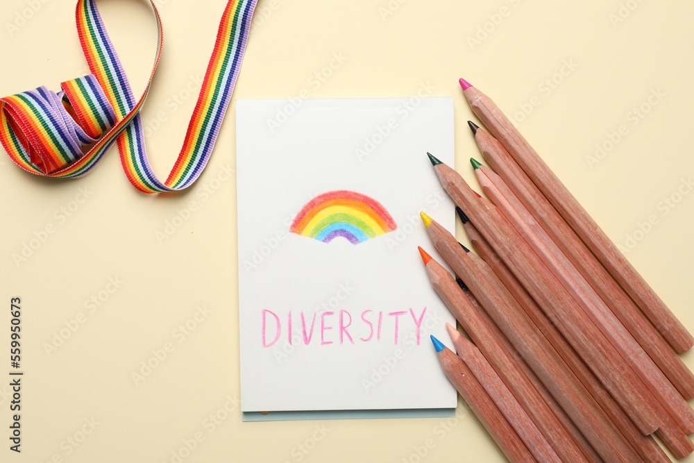 Paper sheet with word Diversity and rainbow, pencils, ribbon on beige background, flat lay