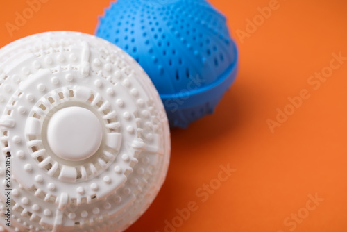 Laundry dryer balls on orange background, closeup. Space for text