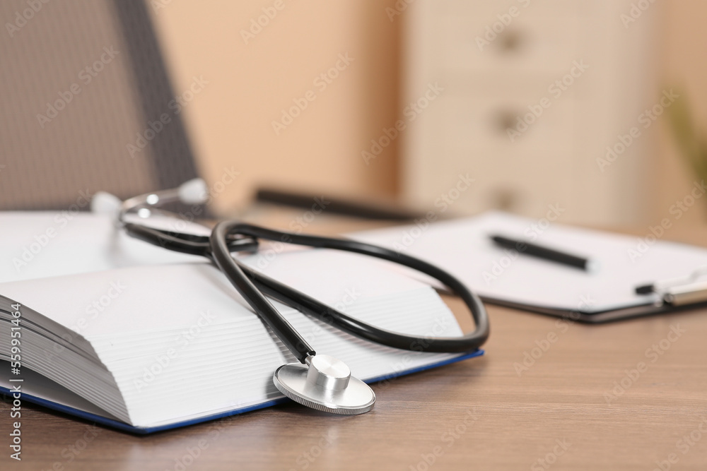 Book and stethoscope on wooden table indoors, space for text. Doctor education Book and stethoscope on wooden table indoors, space for text. Doctor education