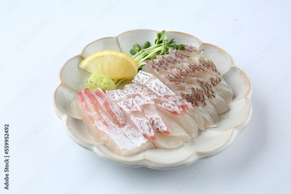There is sashimi on a round plate on a white background. There is sashimi on a round plate on a white background.