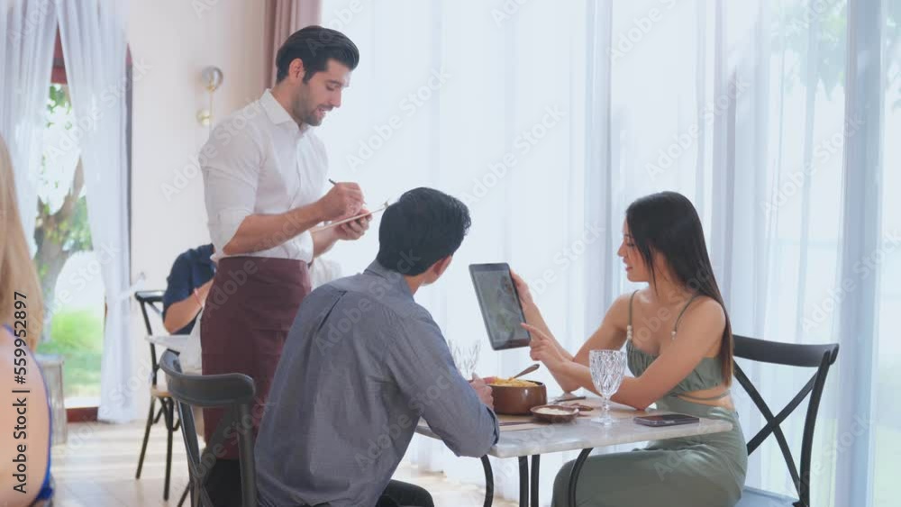 Caucasian waiter receiving order serving from customer in restaurant. Caucasian waiter receiving order serving from customer in restaurant.