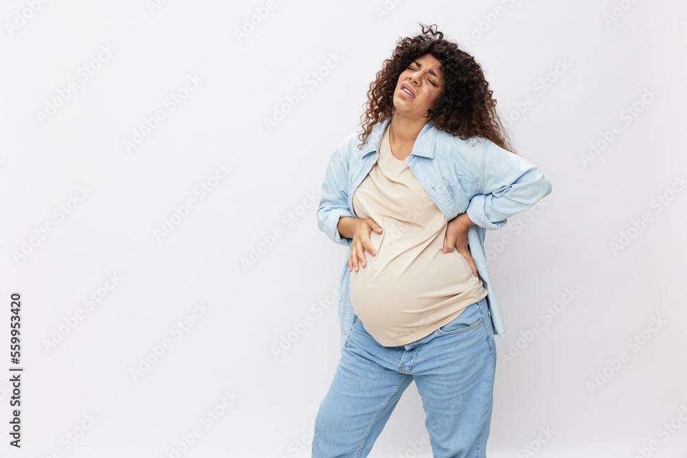 Pregnant woman tired, headache and abdominal pain, heavy pregnancy, last month before childbirth on white isolated background in T-shirt with blue shirt Pregnant woman tired, headache and abdominal pain, heavy pregnancy, last month before childbirth on white isolated background in T-shirt with blue shirt