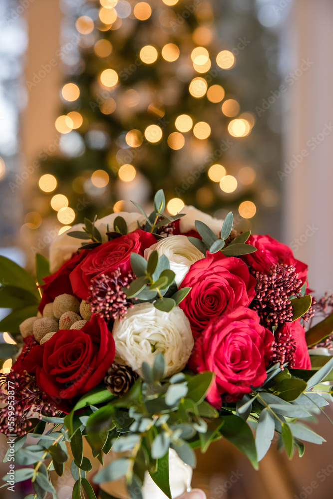 Bridal rose bouquet for Christmas wedding in front of Christmas tree Bridal rose bouquet for Christmas wedding in front of Christmas tree