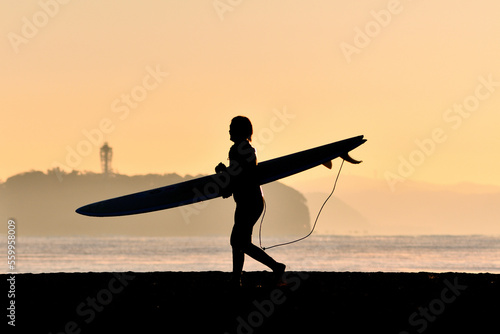 Carta da parati 早朝の砂浜を歩くサーファー（シルエット）