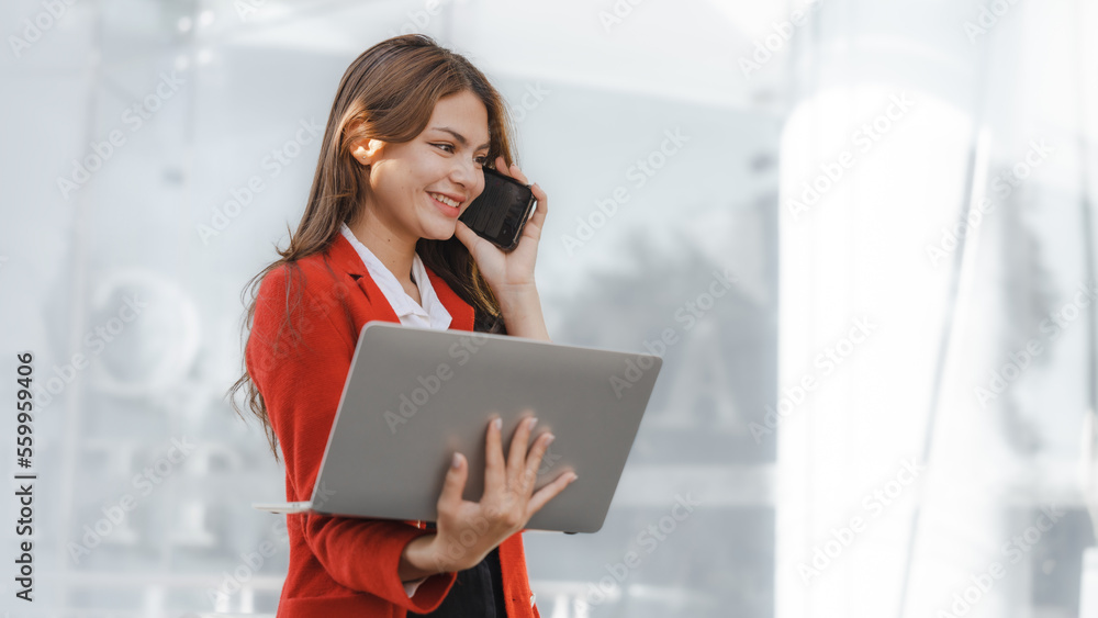 Using laptop, video call, Smiling young Asia business woman leader entrepreneur in red color suit working outdoor urban street walk. Using laptop, video call, Smiling young Asia business woman leader entrepreneur in red color suit working outdoor urban street walk.