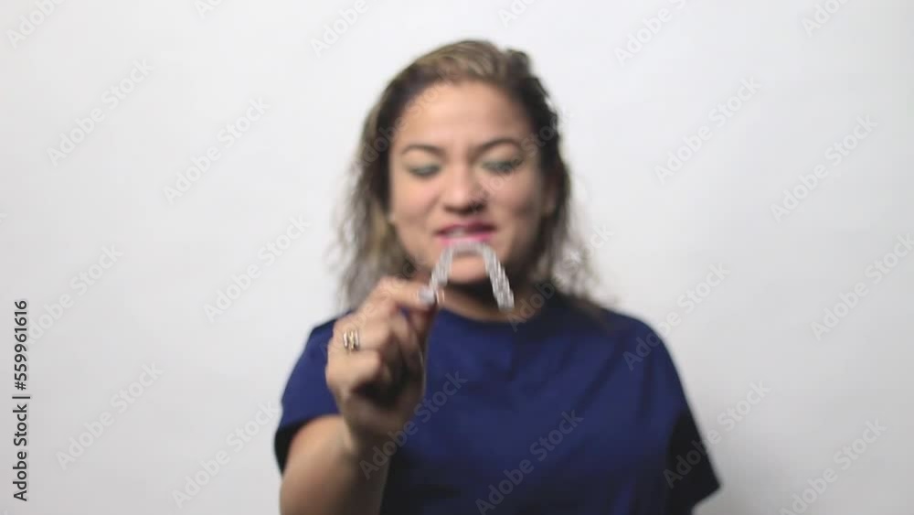 Adult smiling woman holding Invisalign braces in studio, dental healthcare and Orthodontic concept. Adult smiling woman holding Invisalign braces in studio, dental healthcare and Orthodontic concept.