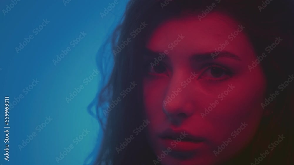 Portrait: a beautiful young Caucasian brunette girl looking at the camera, smiling sexually, a happy person. Red light in the studio, neon. The concept of a strong European hipster woman, Generation Z Portrait: a beautiful young Caucasian brunette girl looking at the camera, smiling sexually, a happy person. Red light in the studio, neon. The concept of a strong European hipster woman, Generation Z