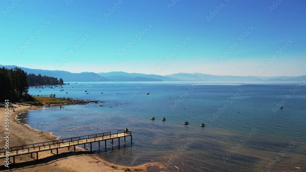 Beautiful Aerial Drone Shot flying over Lake Tahoe, Nevada, USA. Rocks in clear calm blue water. Trees on the foreshore, green forest. Mountains in the background. Boats. High quality 4k footage Beautiful Aerial Drone Shot flying over Lake Tahoe, Nevada, USA. Rocks in clear calm blue water. Trees on the foreshore, green forest. Mountains in the background. Boats. High quality 4k footage