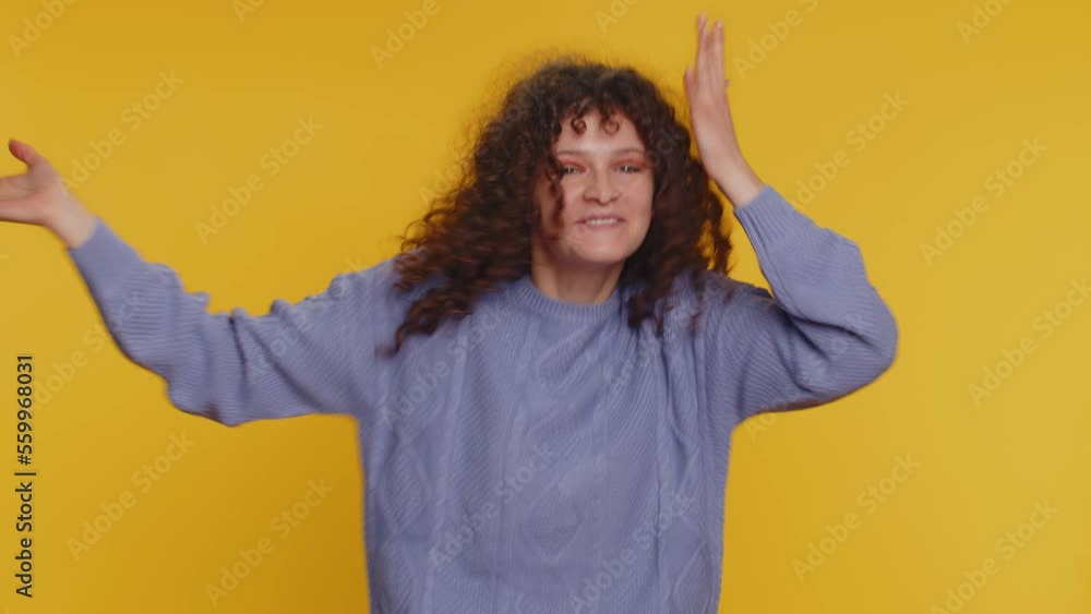 Wow. Hello, welcome. Curly haired woman appear from below waving hi with her palm, greeting with hospitable friendly smile. Young teen girl smiling friendly isolated alone on yellow studio background Wow. Hello, welcome. Curly haired woman appear from below waving hi with her palm, greeting with hospitable friendly smile. Young teen girl smiling friendly isolated alone on yellow studio background